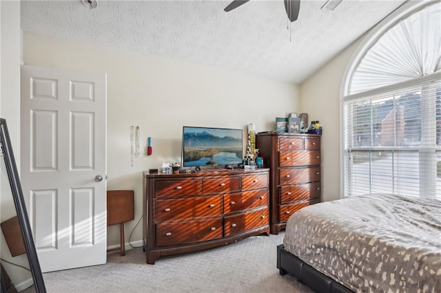 bedroom with carpet flooring, a textured ceiling, lofted ceiling, and a ceiling fan