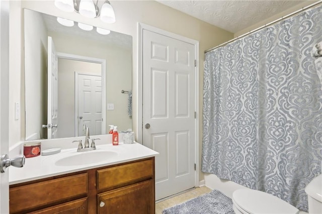 bathroom with toilet, vanity, and a textured ceiling