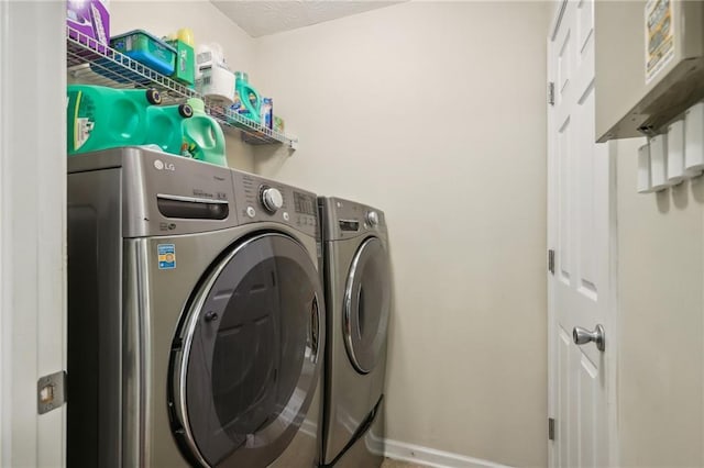 clothes washing area featuring washer and dryer and laundry area