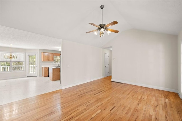 unfurnished living room featuring light wood-type flooring, baseboards, ceiling fan with notable chandelier, and lofted ceiling