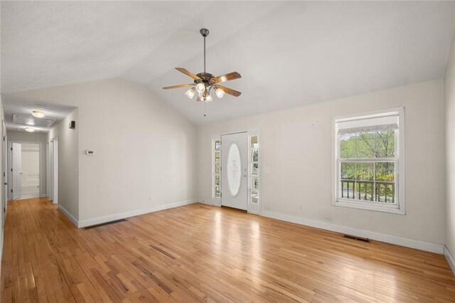 spare room featuring a ceiling fan, visible vents, vaulted ceiling, and light wood-type flooring