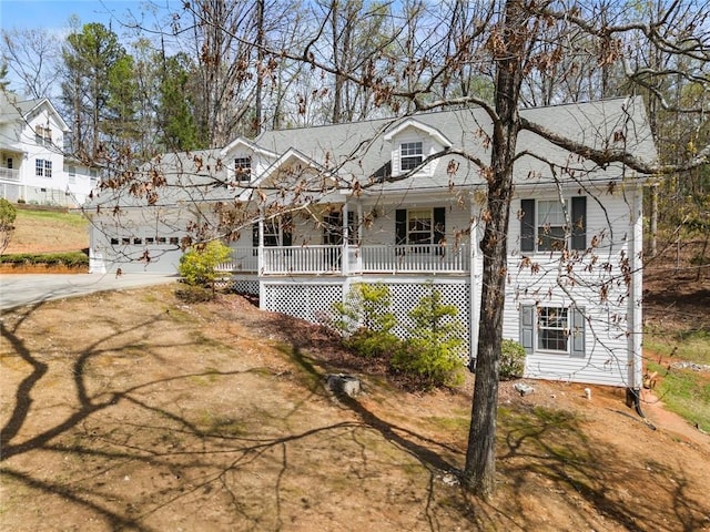 view of front facade with a porch, concrete driveway, and a garage