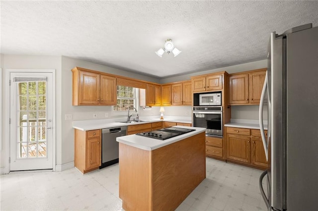 kitchen featuring a sink, light floors, a kitchen island, and stainless steel appliances