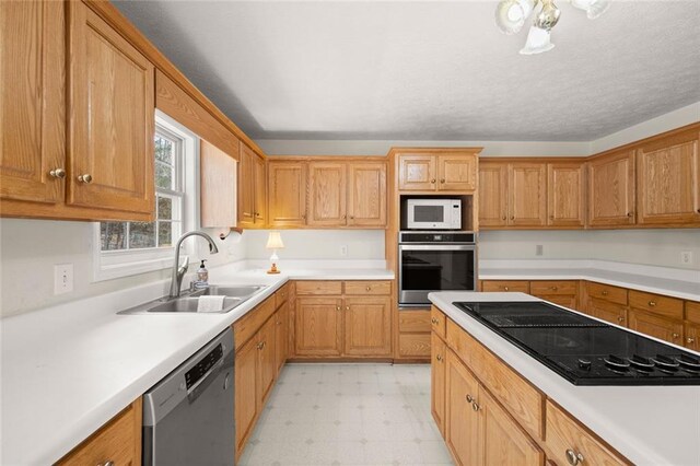 kitchen with light countertops, stainless steel appliances, a sink, and light floors