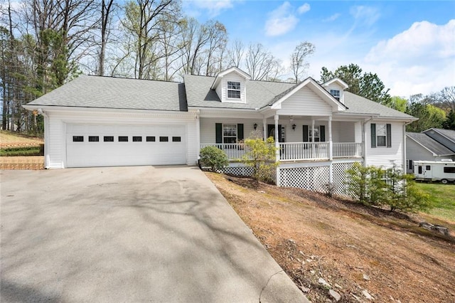 new england style home featuring a porch, concrete driveway, a shingled roof, and a garage