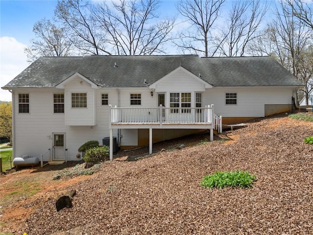 rear view of property with cooling unit and a wooden deck