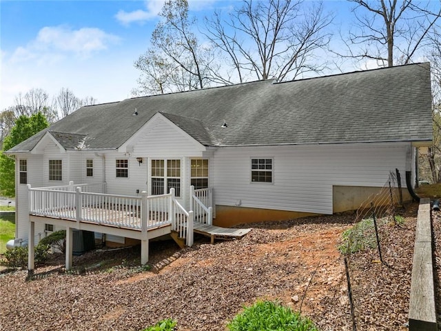 back of property with a wooden deck and roof with shingles