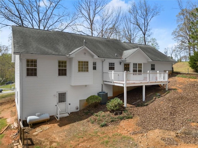 back of property featuring a deck, a shingled roof, and central AC unit