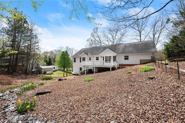 rear view of property featuring fence, a wooden deck, and stairs