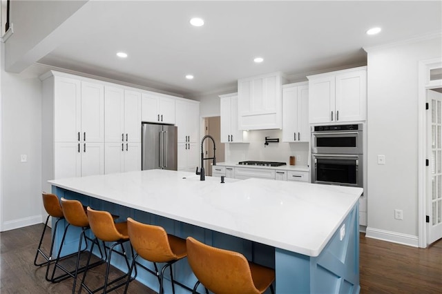 kitchen with white cabinetry, stainless steel appliances, dark wood finished floors, and recessed lighting