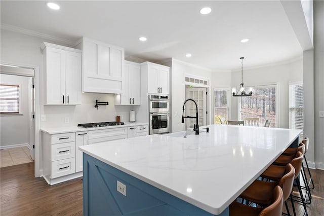 kitchen with a sink, black gas cooktop, crown molding, and stainless steel double oven