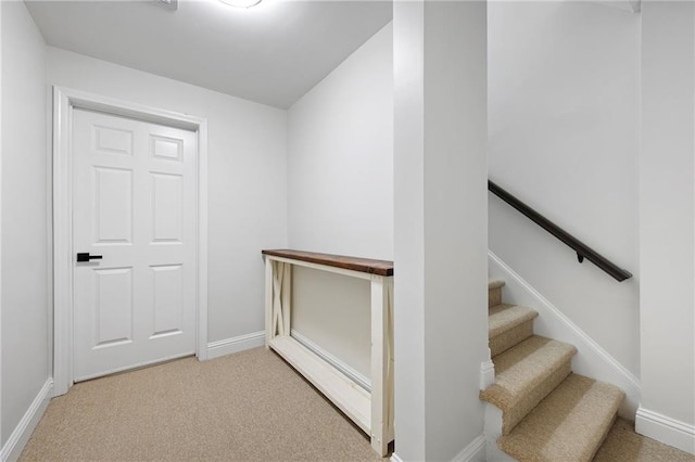 staircase with baseboards and carpet flooring