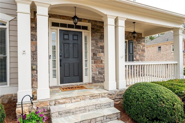 entrance to property featuring stone siding and covered porch