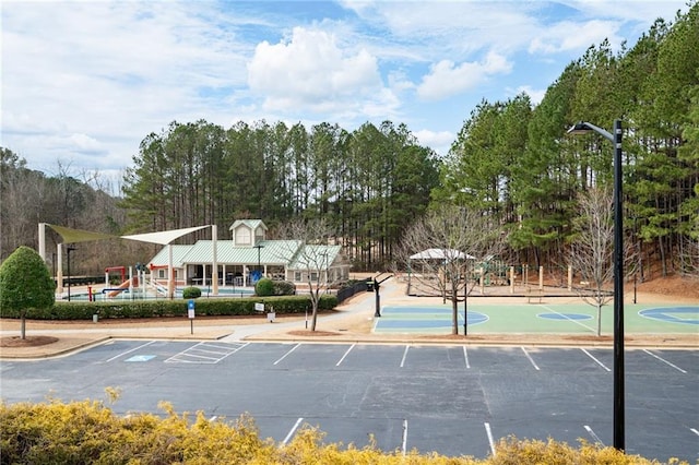 view of sport court featuring community basketball court and playground community