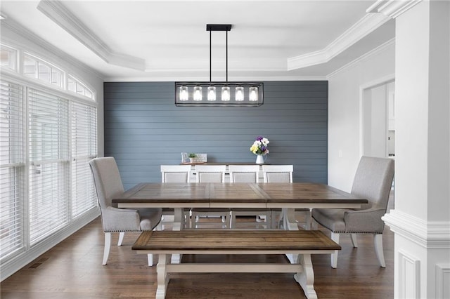 dining room with visible vents, crown molding, and wood finished floors