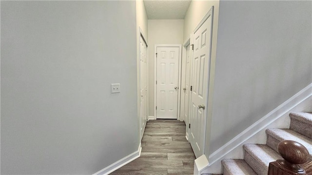staircase featuring baseboards and wood finished floors