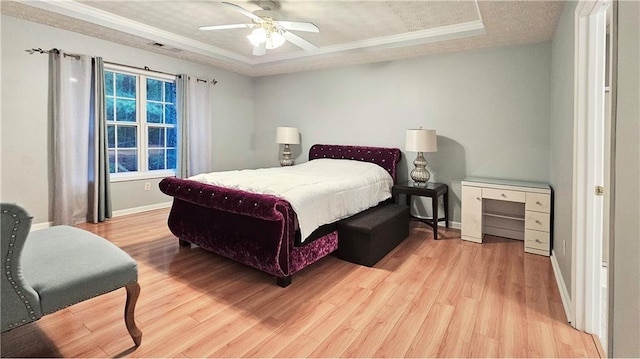 bedroom with a raised ceiling and wood finished floors