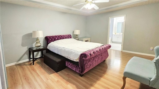 bedroom featuring light wood-style flooring, baseboards, crown molding, ensuite bathroom, and a ceiling fan