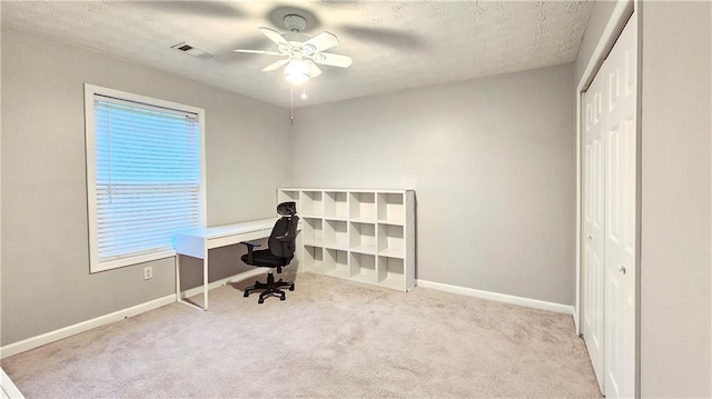 office space with a ceiling fan, carpet, baseboards, and a textured ceiling