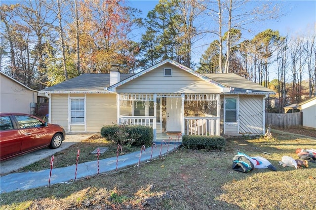 bungalow with covered porch and a front yard