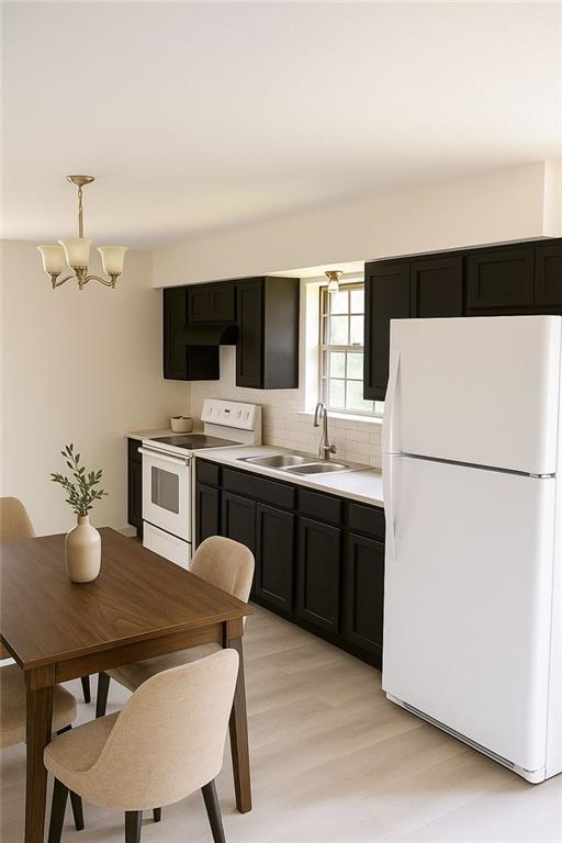 13 Travis Rd, Rossville, GA 30741 - kitchen featuring white appliances, a chandelier, tasteful backsplash, light wood-type flooring, and dark cabinets
