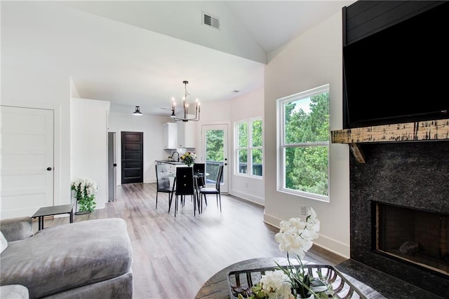 271 Moorings Run, Jasper, GA 30143 - living area featuring a fireplace, light wood-style flooring, a chandelier, and lofted ceiling