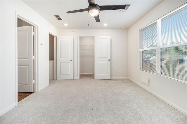 unfurnished bedroom featuring ceiling fan, light carpet, and a closet