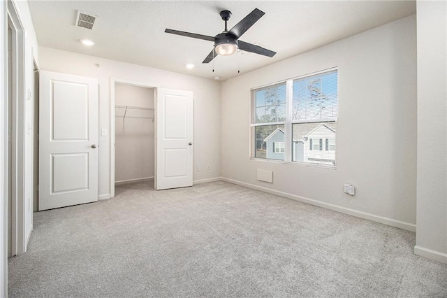 unfurnished bedroom with ceiling fan, light colored carpet, and a closet