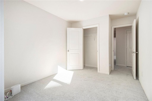 unfurnished bedroom with light colored carpet and a closet