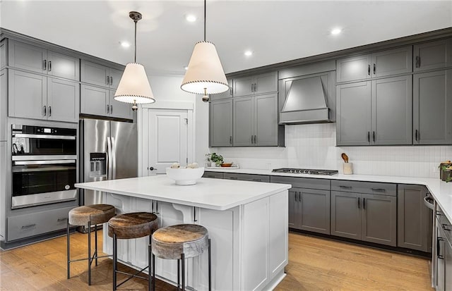 363 Aidens Blf, Jefferson, GA 30549 - kitchen featuring custom exhaust hood, gray cabinets, stainless steel appliances, a kitchen island, and a breakfast bar