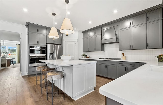363 Aidens Blf, Jefferson, GA 30549 - kitchen with appliances with stainless steel finishes, wall chimney range hood, gray cabinets, a kitchen island, and crown molding