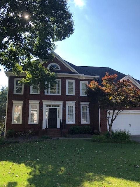 view of front of home with a garage and a front lawn