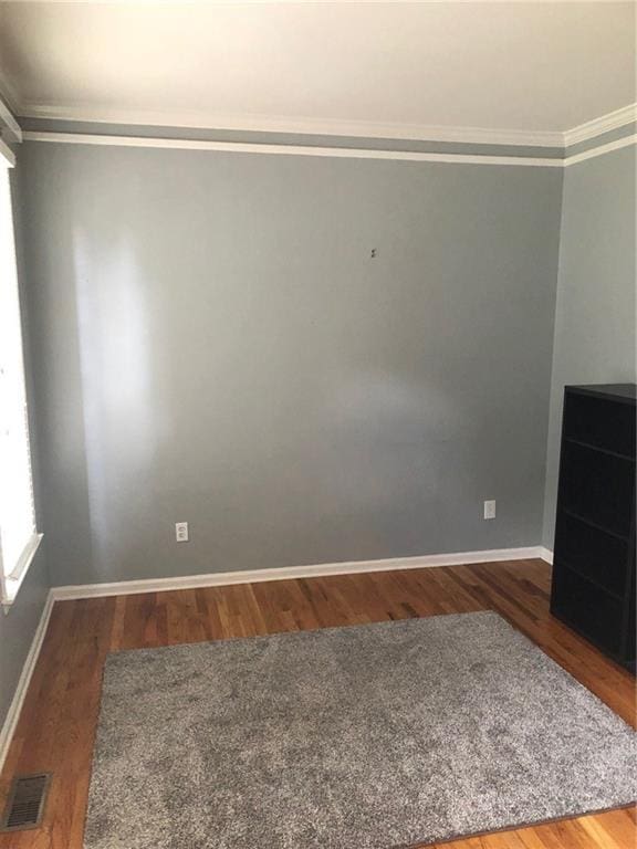 unfurnished room featuring dark hardwood / wood-style flooring and crown molding