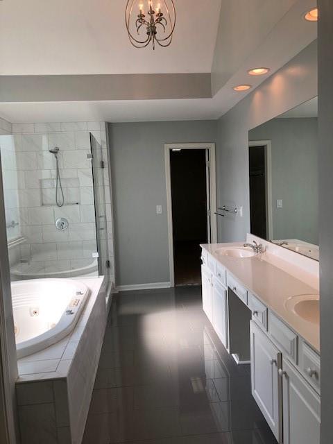 bathroom featuring independent shower and bath, a chandelier, tile patterned floors, and vanity