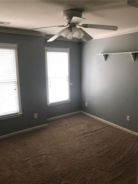 spare room with ceiling fan, carpet flooring, and plenty of natural light