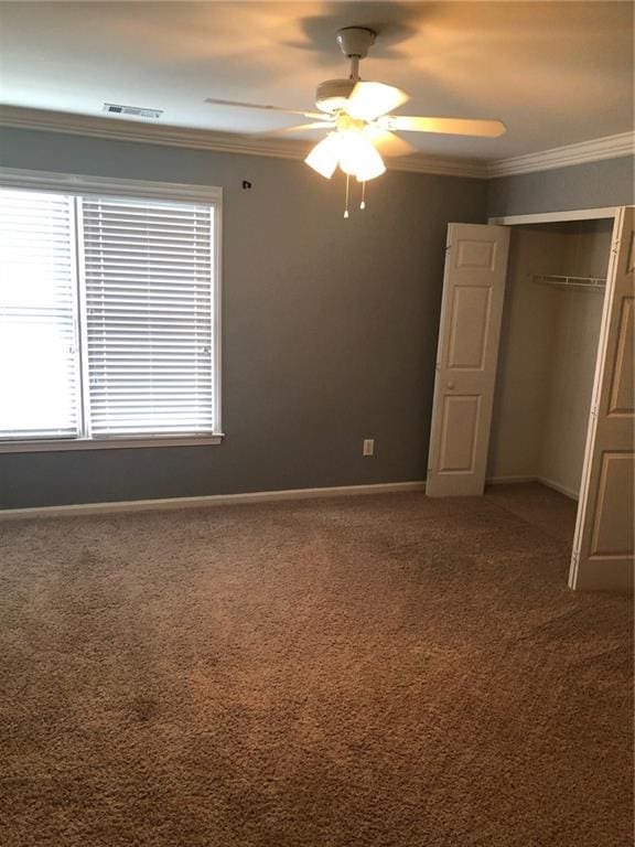 unfurnished bedroom with a closet, ceiling fan, carpet, and ornamental molding