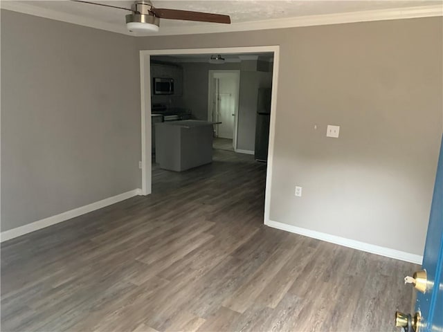 spare room featuring dark hardwood / wood-style flooring, ceiling fan, and crown molding