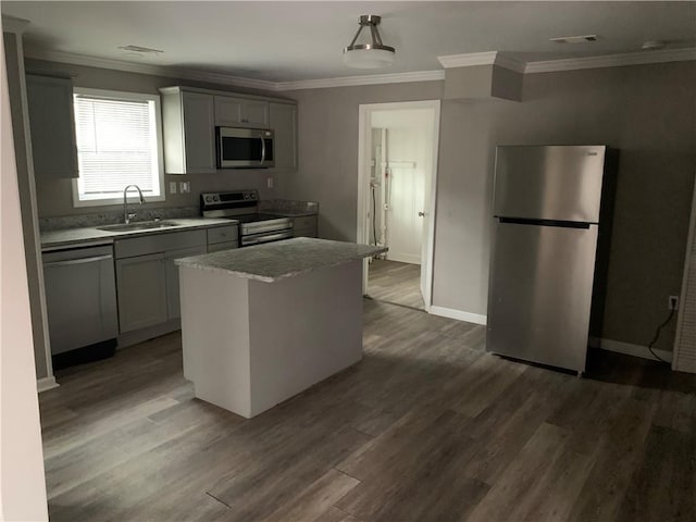 kitchen featuring dark hardwood / wood-style floors, a kitchen island, sink, and appliances with stainless steel finishes