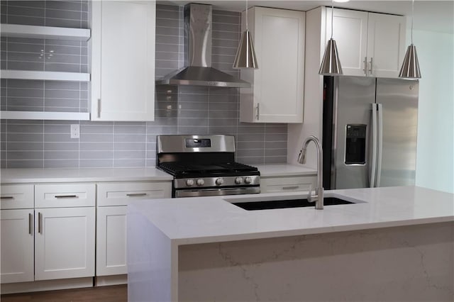 kitchen with white cabinetry, stainless steel appliances, light stone countertops, wall chimney exhaust hood, and sink