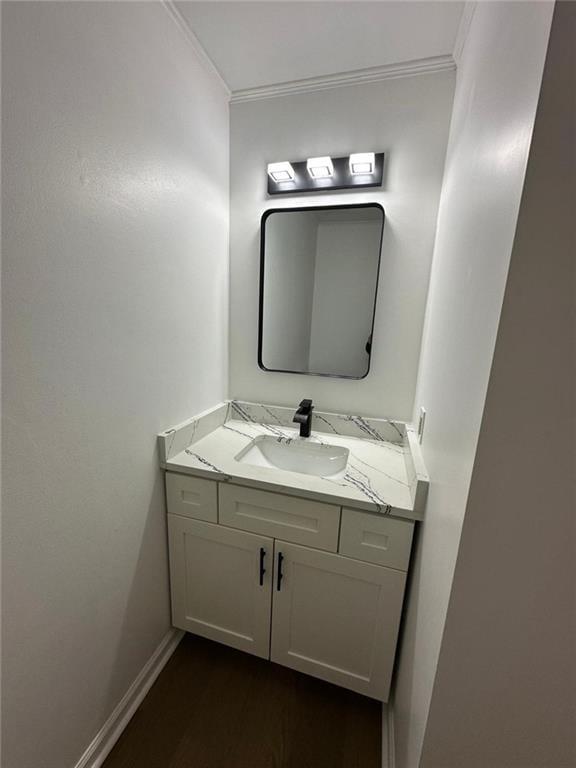 bathroom featuring vanity, crown molding, and hardwood / wood-style flooring