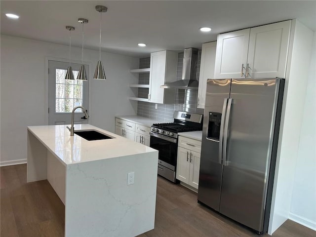 kitchen with wall chimney range hood, sink, white cabinetry, hanging light fixtures, and stainless steel appliances