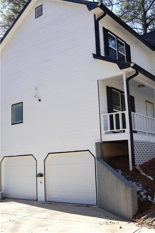 view of side of property with a garage and covered porch