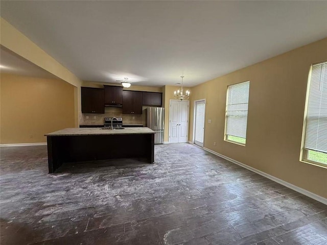 102 Daisy Cir, Mcdonough, GA 30252 - kitchen with freestanding refrigerator, a chandelier, a sink, a kitchen island with sink, and dark brown cabinetry