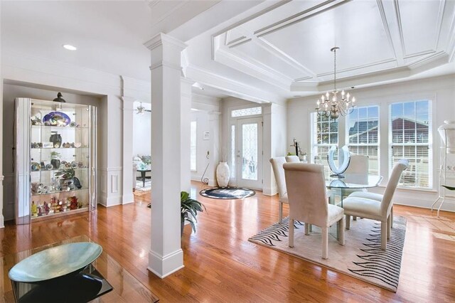 dining space featuring a raised ceiling, an inviting chandelier, hardwood / wood-style flooring, and plenty of natural light