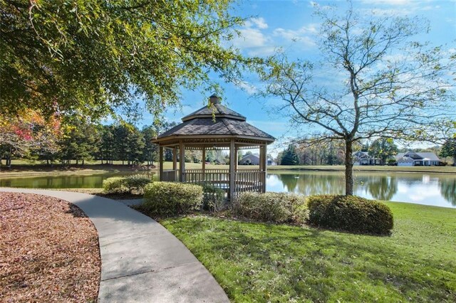 view of property's community with a water view, a lawn, and a gazebo