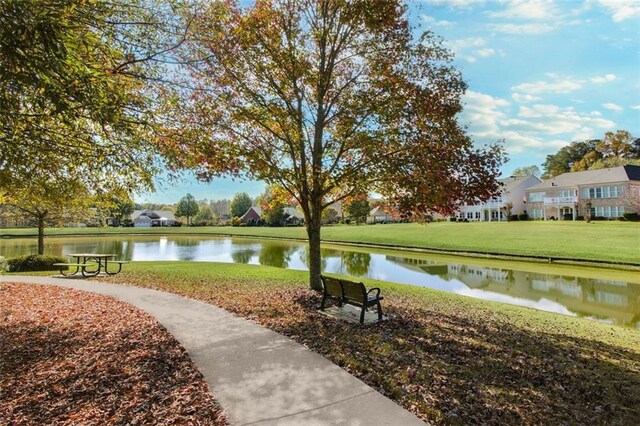 view of property's community with a water view and a yard