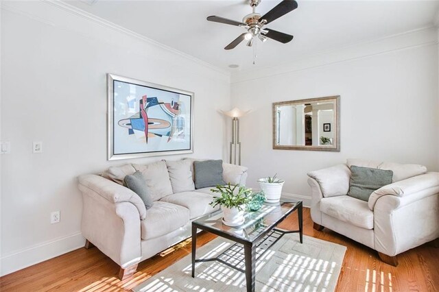 living room with ceiling fan, wood-type flooring, and ornamental molding