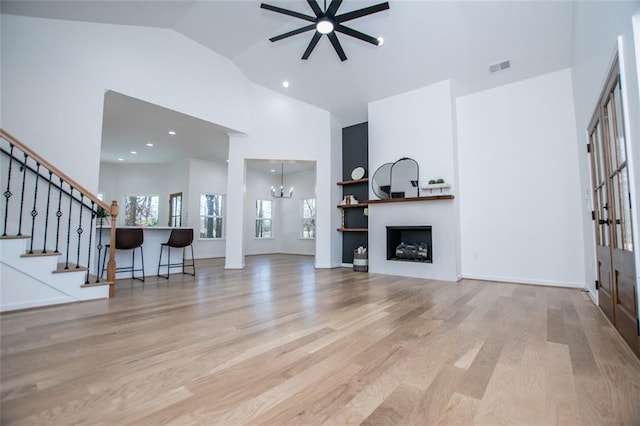 90 Ayers Rd, Bowdon, GA 30108 - unfurnished living room featuring high vaulted ceiling, wood finished floors, ceiling fan, a fireplace, and stairway
