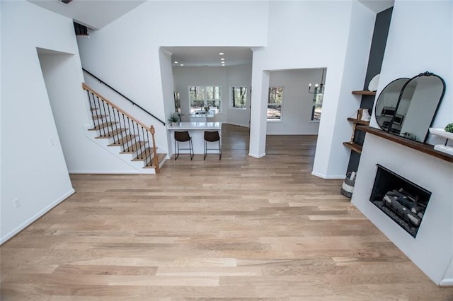 90 Ayers Rd, Bowdon, GA 30108 - entryway with wood finished floors, stairs, a fireplace, a chandelier, and a high ceiling