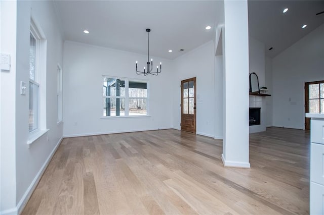 90 Ayers Rd, Bowdon, GA 30108 - unfurnished living room featuring a high ceiling, a chandelier, light wood-style floors, a fireplace, and recessed lighting